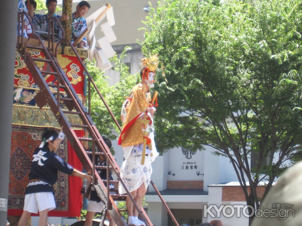 強力の肩に乗って降りてくる長刀鉾の稚児