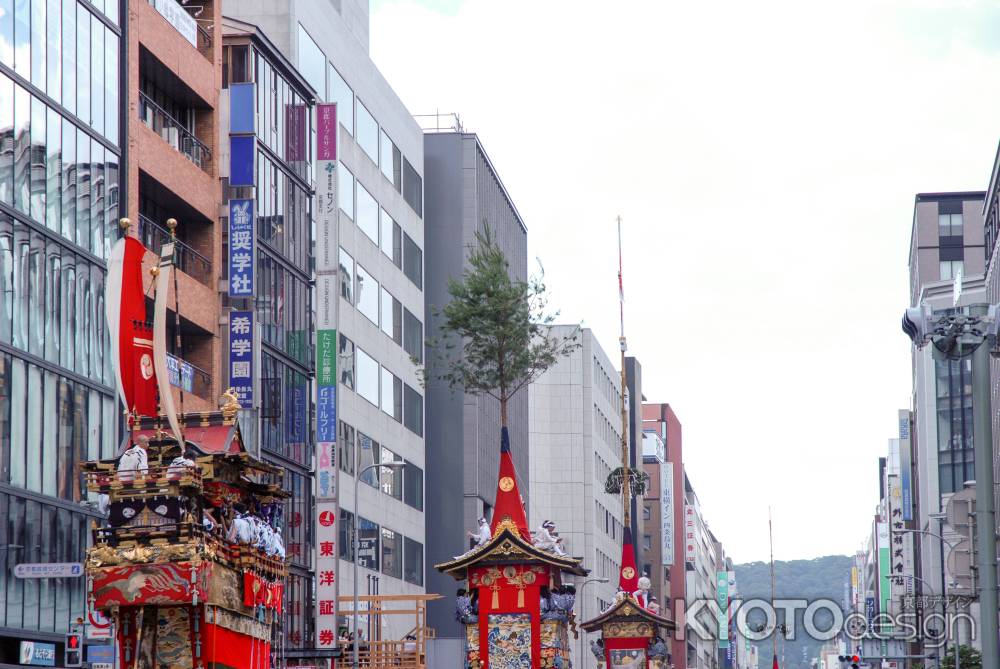 ビル街を行く鉾や山